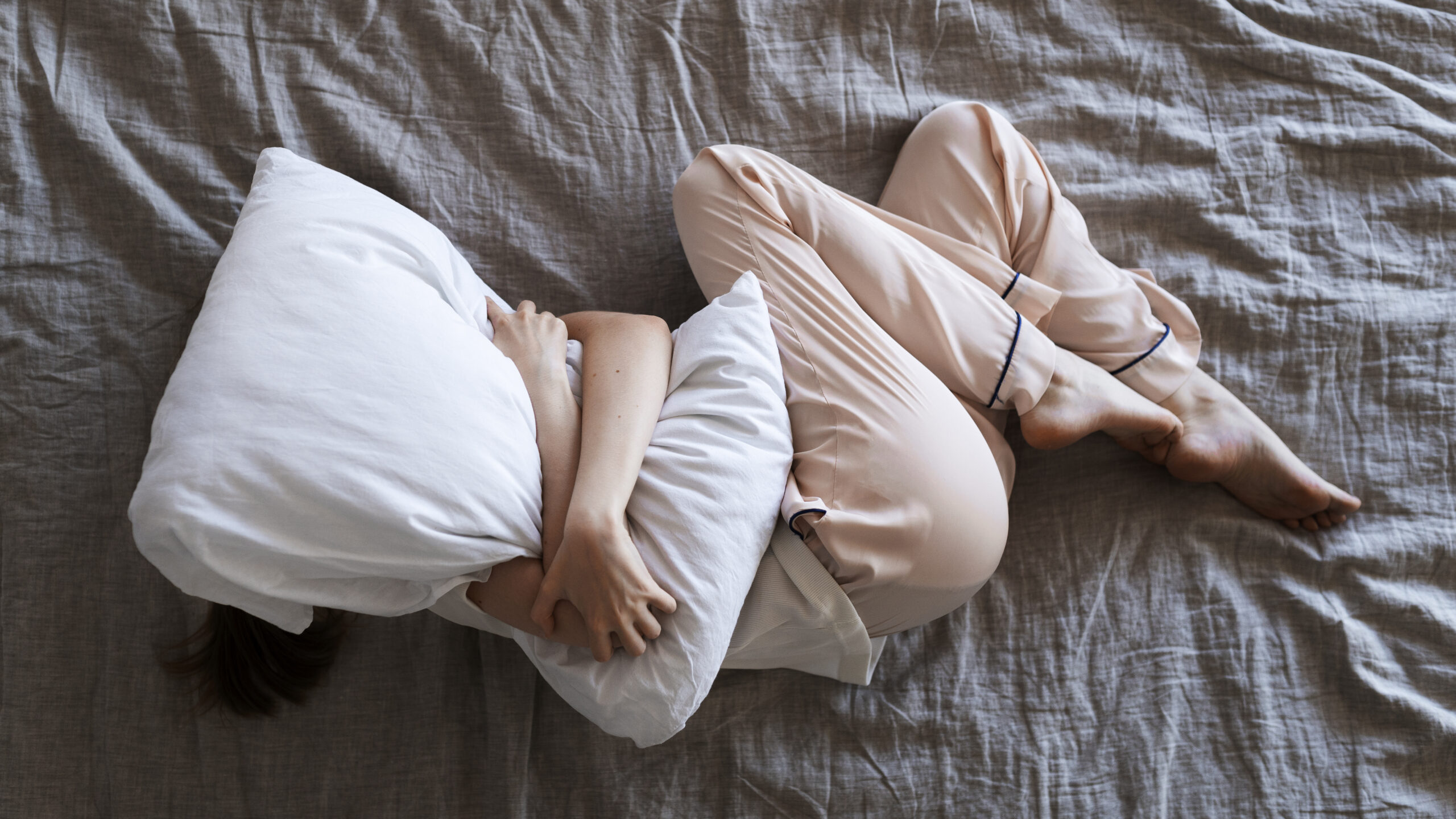 top view woman laying bed with pillow scaled