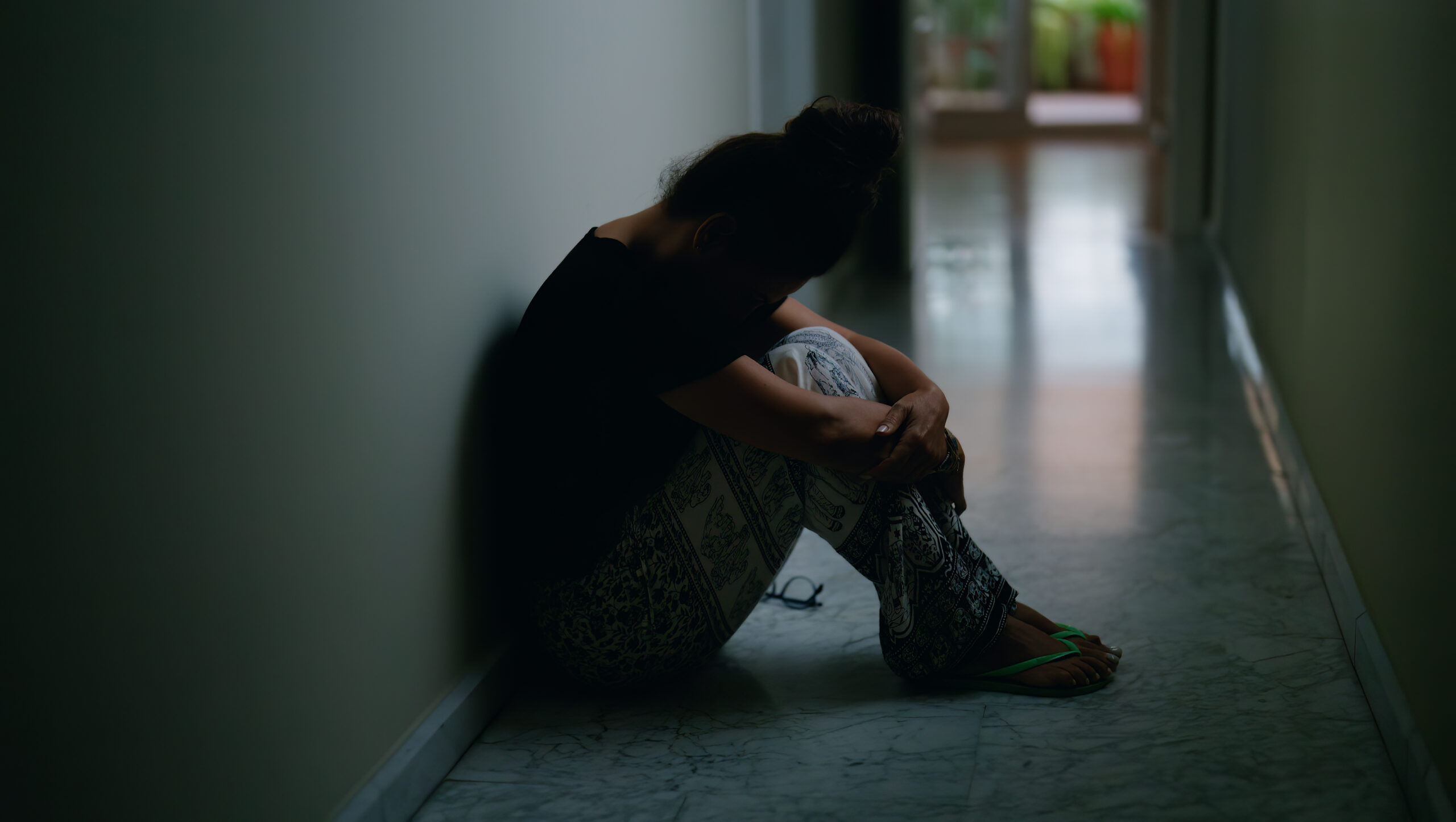 middle age hispanic woman suffering domestic violence with bruise eyes sitting floor home scaled